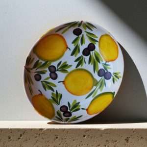Italian handcrafted ceramics with lemon and olive decoration on a white background