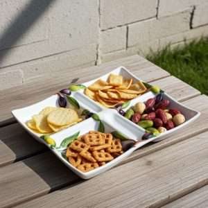 white ceramic appetizer tray decorated with lemons and olives on a white background