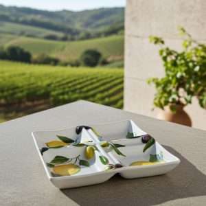 white ceramic appetizer tray decorated with lemons and olives on a white background