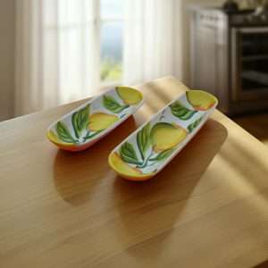 white ceramic boat decorated with lemons and leaves on a white background