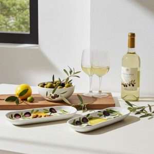 ceramic boat-shaped container with lemon and olive design on a white background