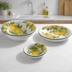 Ceramic serving set consisting of a central bowl, a small bowl, and a plate, featuring a lemon and leaf design on a white background.<br srcset=