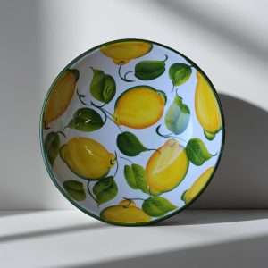 Details of a white ceramic bowl decorated with lemons and leaves on a white background