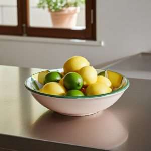 white ceramic bowl decorated with lemons and leaves on a white background