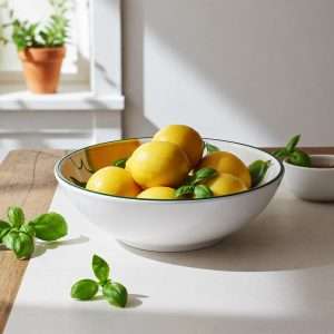 ciotola in terracotta con decoro in limone e foglie su sfondo bianco