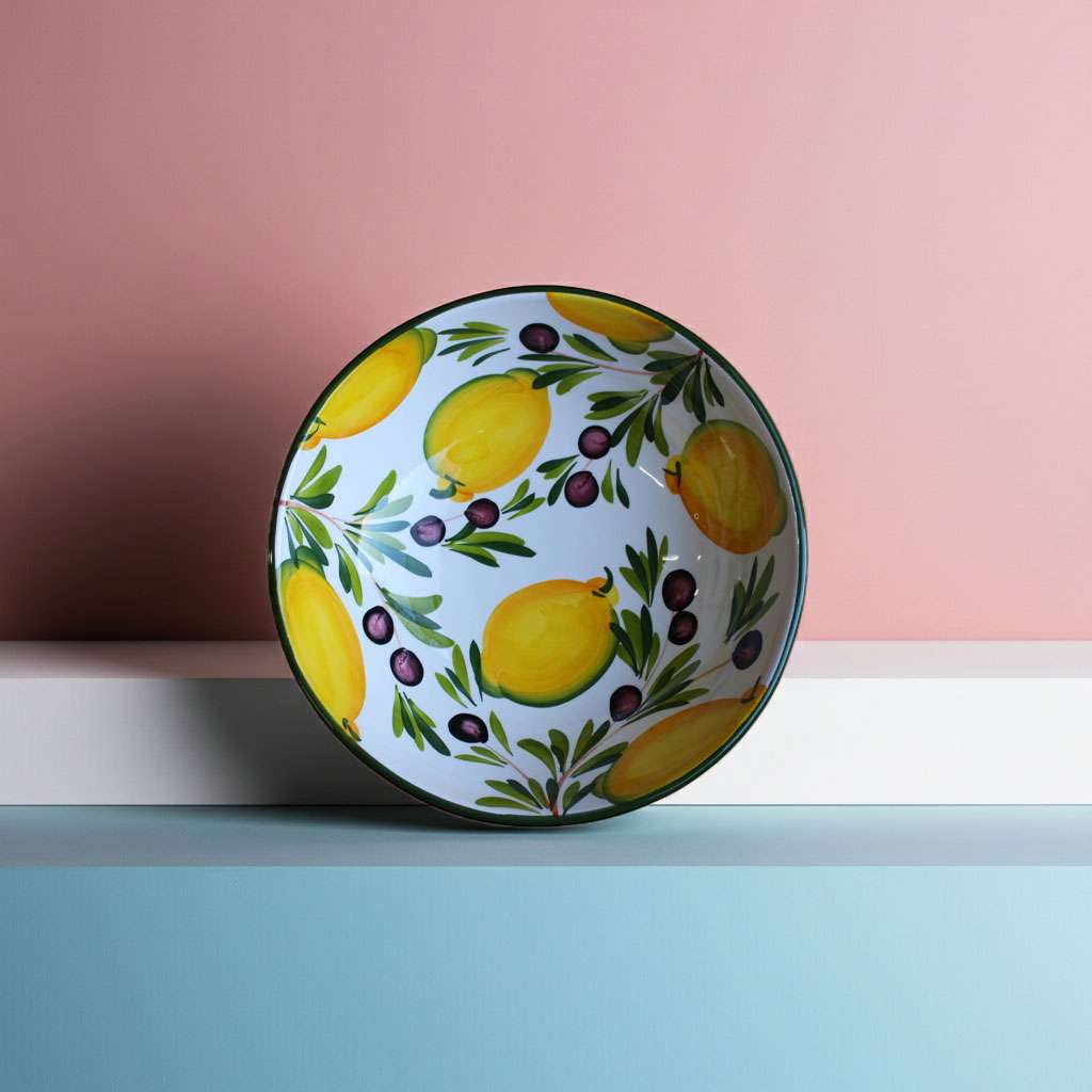 detail of a hand-painted bowl with lemon and olive design on a white background