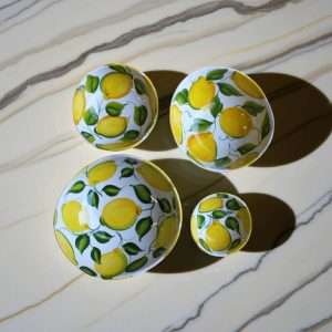 dettagli di contenitori in ceramica bianca in varie misure con decoro limone e foglie su sfondo bianco