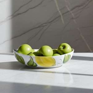 ceramic jade is a bowl decorated with lemons and leaves on a white background