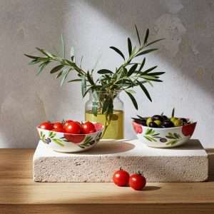 Italian ceramic bowls in various sizes decorated with tomato and olive design on a white background