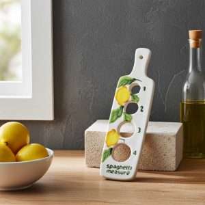 misura spaghetti in ceramica decorato con limone, foglie e olive su sfondo bianco