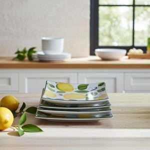 Stacked square ceramic plates with a lemon and leaf design on a white background.