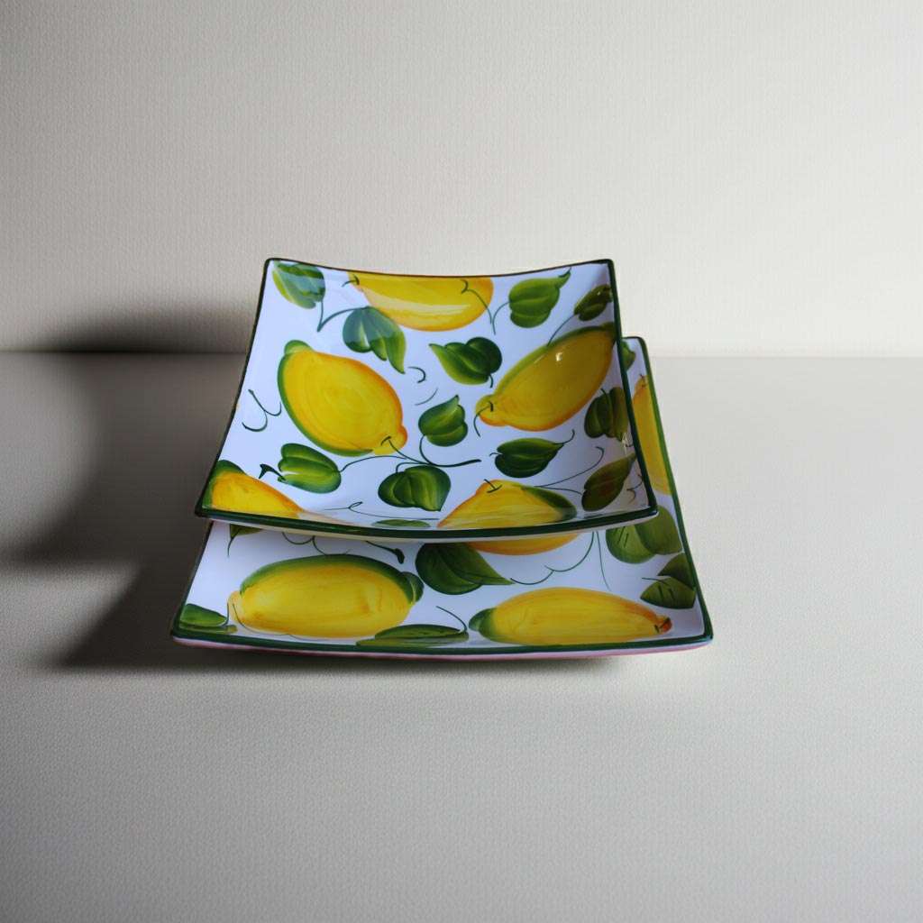 details of square ceramic plates featuring a lemon and leaf design on a white background.