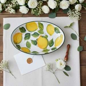 ceramic baking dish with lemon and leaf design on a white background