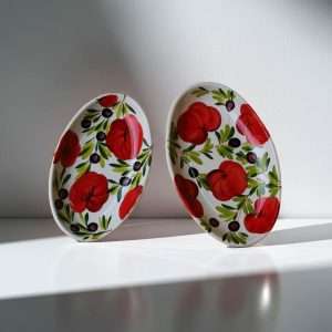 Ceramic baking dishes with tomato and olive decoration on white background
