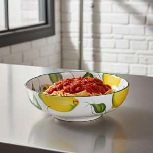 spaghettata in ceramica decorata con limoni e foglie su sfondo bianco