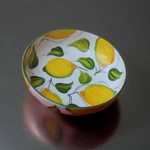 dettagli di spaghettata in ceramica decorata con limoni e foglie su sfondo bianco