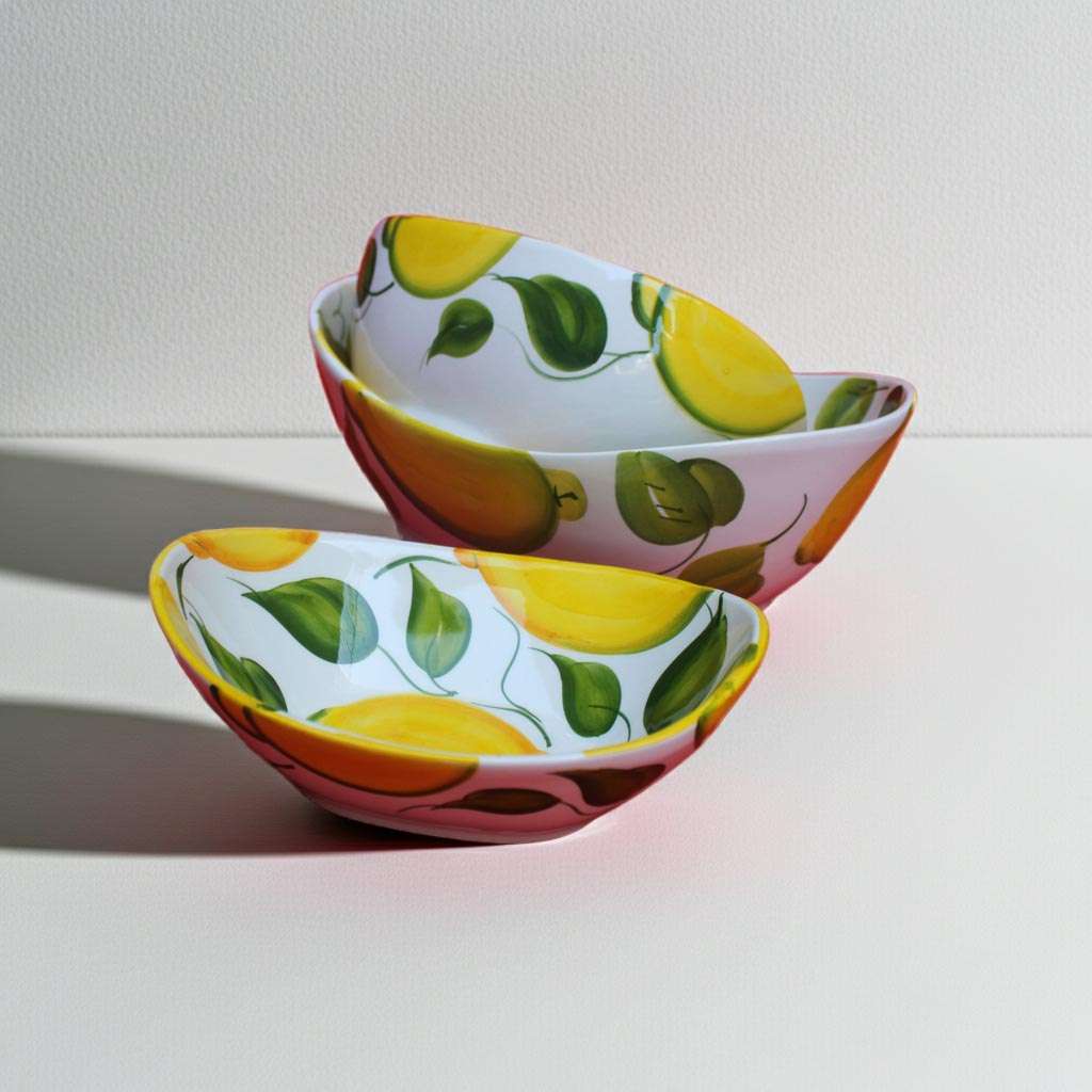 handmade ceramic bowl decorated with lemons and leaves on a white background