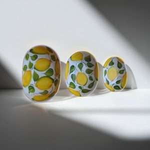 set of handcrafted ceramic bowls decorated with lemons and leaves on a white background
