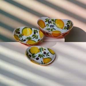 details of ceramic bowl with lemon and olive decoration on white background