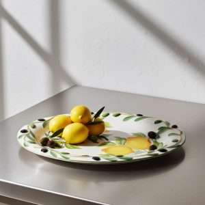grande vassoio in ceramica in rilievo con limone e olive su sfondo bianco