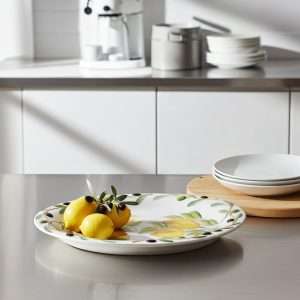 Dettaglio di grande vassoio ovale in ceramica decorato a mano con limoni e olive nere