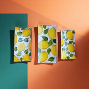 set of rectangular ceramic trays, in various sizes, with lemon and leaf decoration on a white background