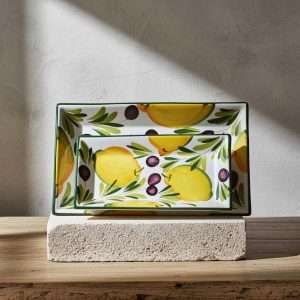 ceramic tray decorated with lemons and olives on a white background