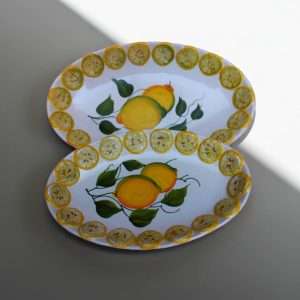 dettagli di vassoio per dolci decorato con limoni e foglie su sfondo bianco