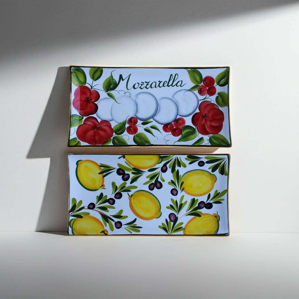 Details of a white ceramic tray with lemon, olive, tomato, and mozzarella decorations on a white background.