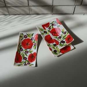 details of ceramic trays with tomato and olive decoration on white background