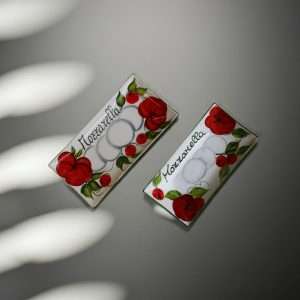 details of rectangular white ceramic trays decorated with tomato and mozzarella design on a white background