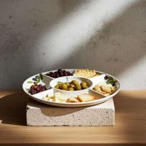 details of the handcrafted appetizer tray with tomato and olive design on a white background