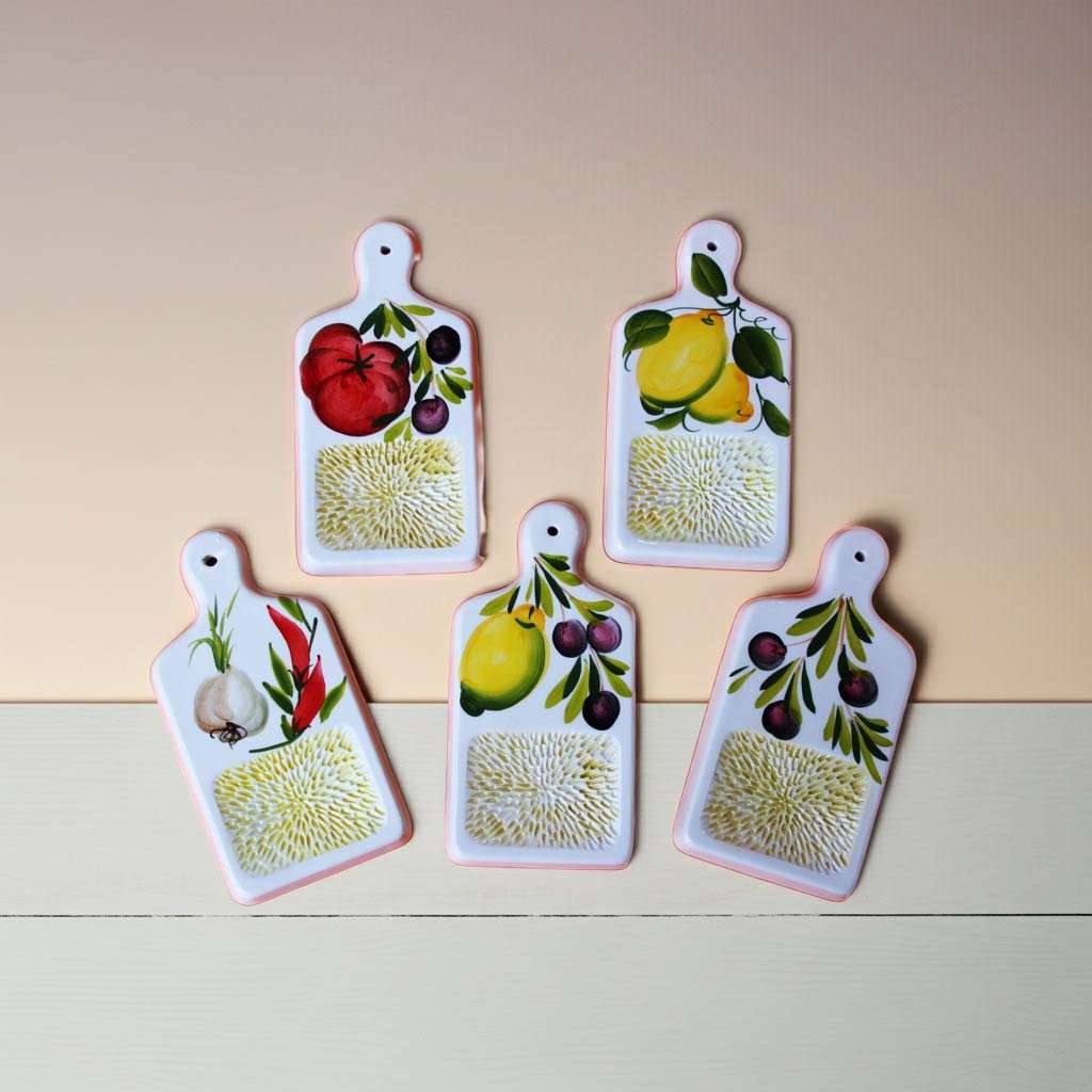 set di gratta aglio in ceramica bianca con vari decori su sfondo bianco