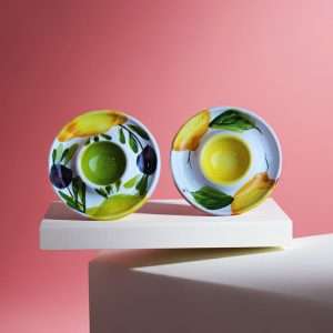 details of a ceramic egg holder with lemon and olive design on a white background