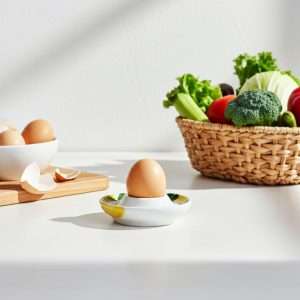 ceramic egg holder with lemon and olive design on a white background