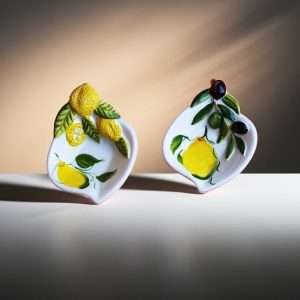 details of ceramic sauce boat in two designs: lemon, and lemon with olive on a white background