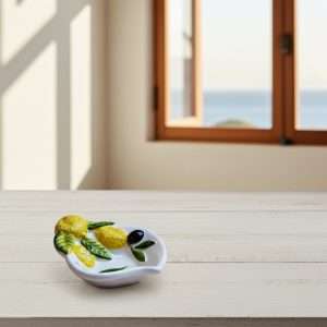ceramic sauce boat in two designs: lemon, and lemon with olive on a white background