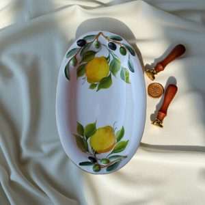 details of small appetizer tray with lemon and olive design on a white background
