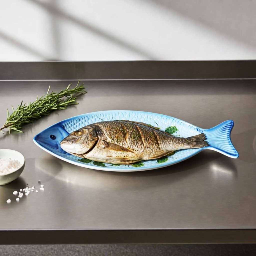 Fish tray for serving seafood dishes with lemon decoration on a white and blue background