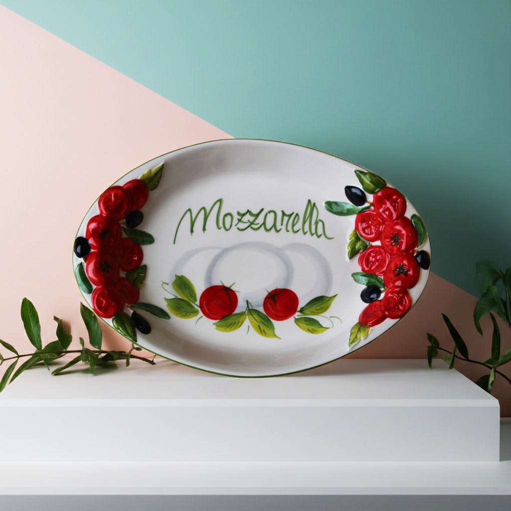 handcrafted ceramic tray with embossed tomato decorations and a central mozzarella design on a white background